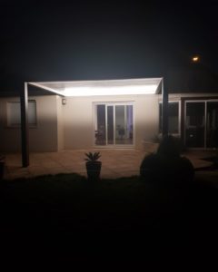 Pergola bioclimatique Couleur structure mars 2525, lames blanches 9016. vue de nuit avec éclairage LED intégré